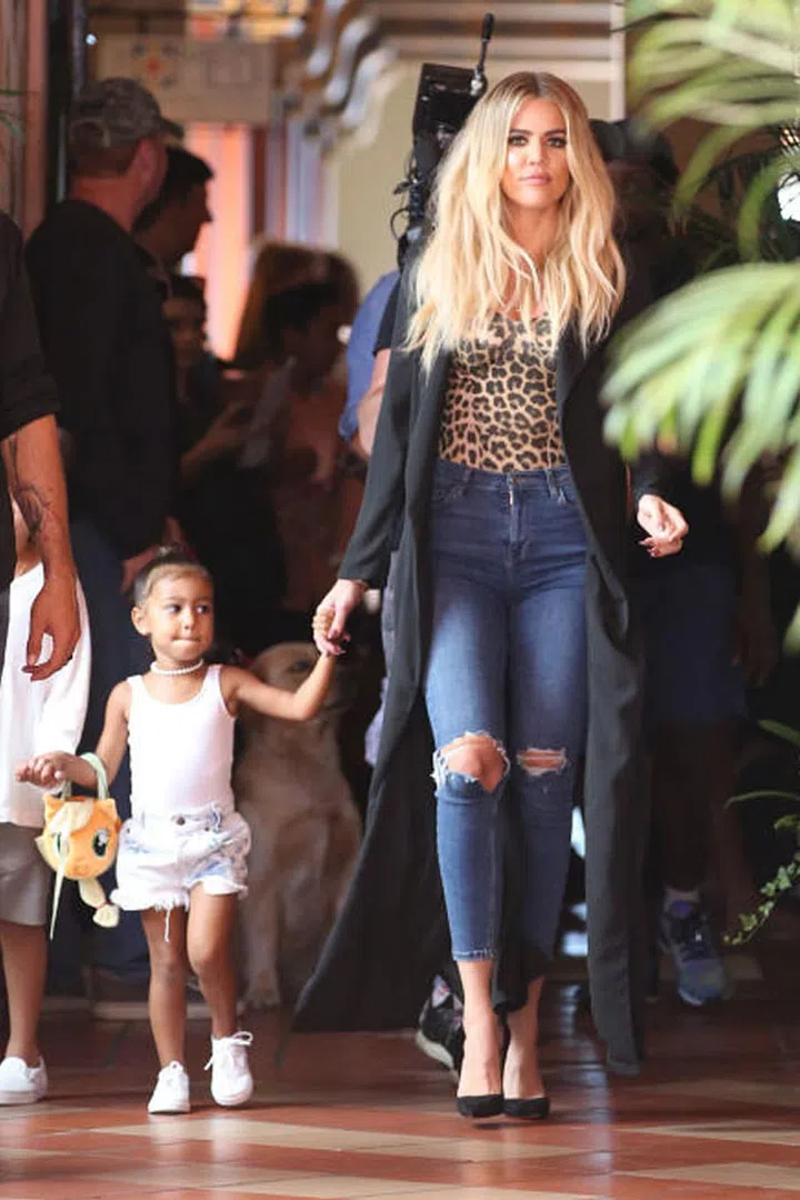 North wears a pearl choker, denim cutoffs and carries a plush kitty kat purse (most likely couture) while out with the Kardashian-Jenner clan.