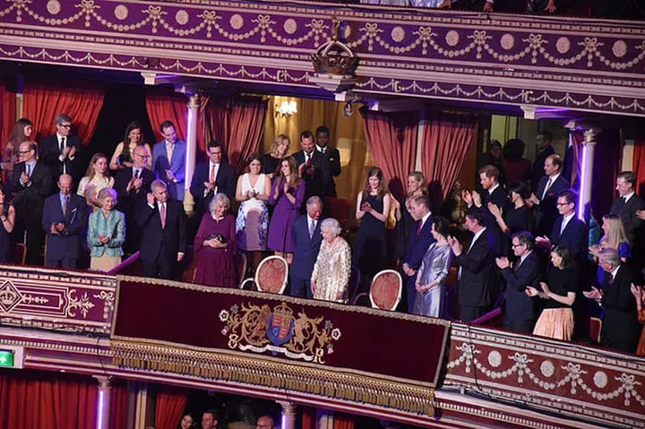 The royal family stands at the arrival of the birthday girl.