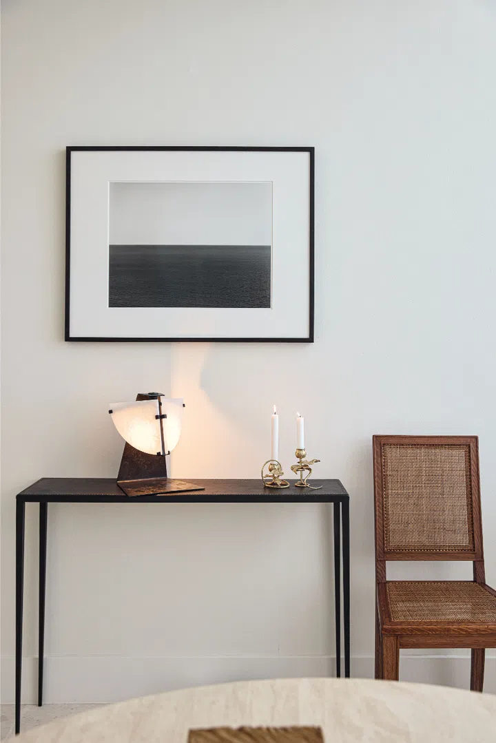 A Hiroshi Sugimoto photograph, Pierre Chareau lamp, Claude Lalanne candle holders, and Jean-Michel Frank table and chair.