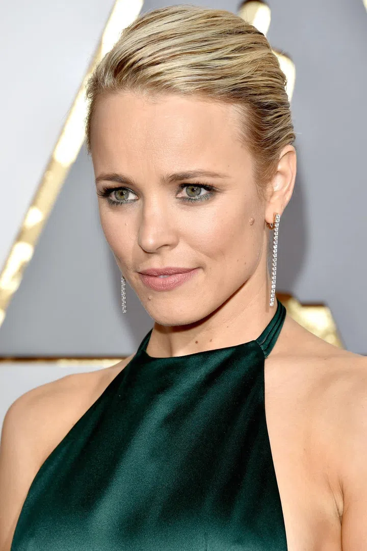 The actress goes minimal from head to toe—pairing her silk emerald August Getty gown with shoulder-grazing diamond earrings.