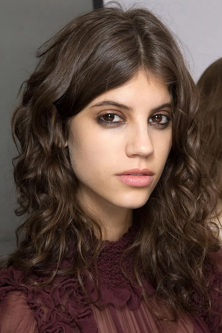 Adventure-seeking, well-traveled women—the kind who manage to look effortlessly chic as they weave in and out of traffic and across the countryside on motorcycles—inspired the weathered eye makeup and lightly flattened hair on the models at Chloé. Aaron de Mey drew black liner with a greasy finish along the waterline, dragged it down under the eyes and then wiped the color away with a Q-tip dipped in gloss. "I'm trying to get them to look imperfect, asymmetric and worn-in, like they've had the makeup on for a couple days. But not in the sense of looking rough; I just want to give them a slight toughness."
