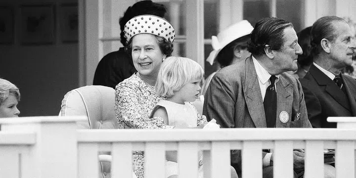Zara Phillips, daughter of Princess Anne and Captain Mark Phillips, sits on the Queen's lap during a polo match. Photo: Getty