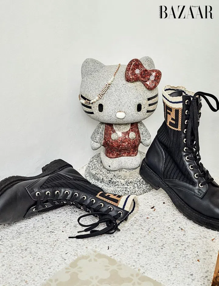 Keeping company with Fendi boots and a Dior necklace, a Hello Kitty stone statue adds quirk to a corner.