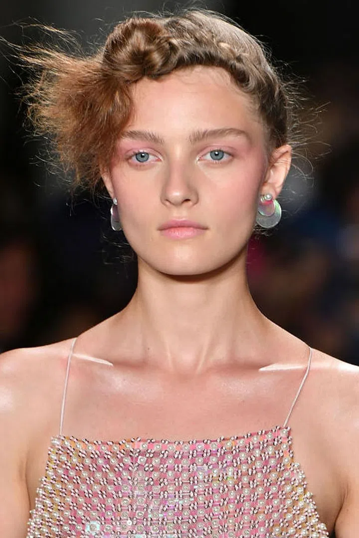 You can blame it on Stranger Things. The '80s are back and they're fresher than ever; just look at the glowing pink makeup seen backstage at Adam Selman. After prepping and moisturizing the skin, makeup artist Emi Kaneko traced a rosy, multipurpose cream color (MAC Casual Color in For Your Amusement) across the cheekbones, up toward the eyes, and all over the eyelids, giving that distinct '80s draping effect. The color was also dabbed on the lips. 