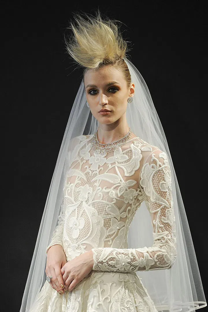 At Naeem Khan, brides went punk. Sooty dark eyeliner was kept glam with the addition of a creamy matte lipstick, but this look was all about the hair. Teased into a faux-hawk, the hair look was anything but safe.