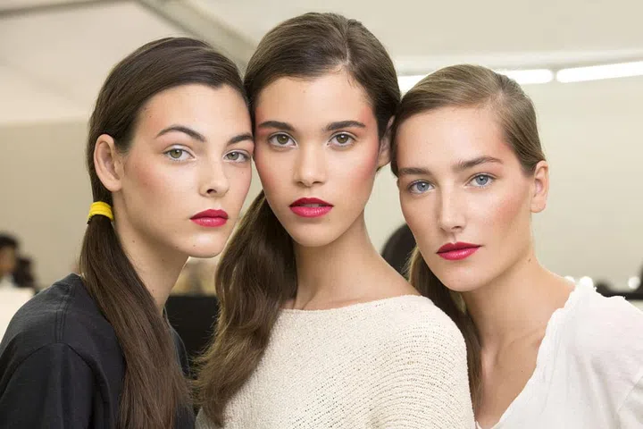Glossy pink lips and a swipe of rosy blush (Chanel Coco Code Exclusive Creation Blush Harmony, available in January) made a colorful statement backstage at Chanel.