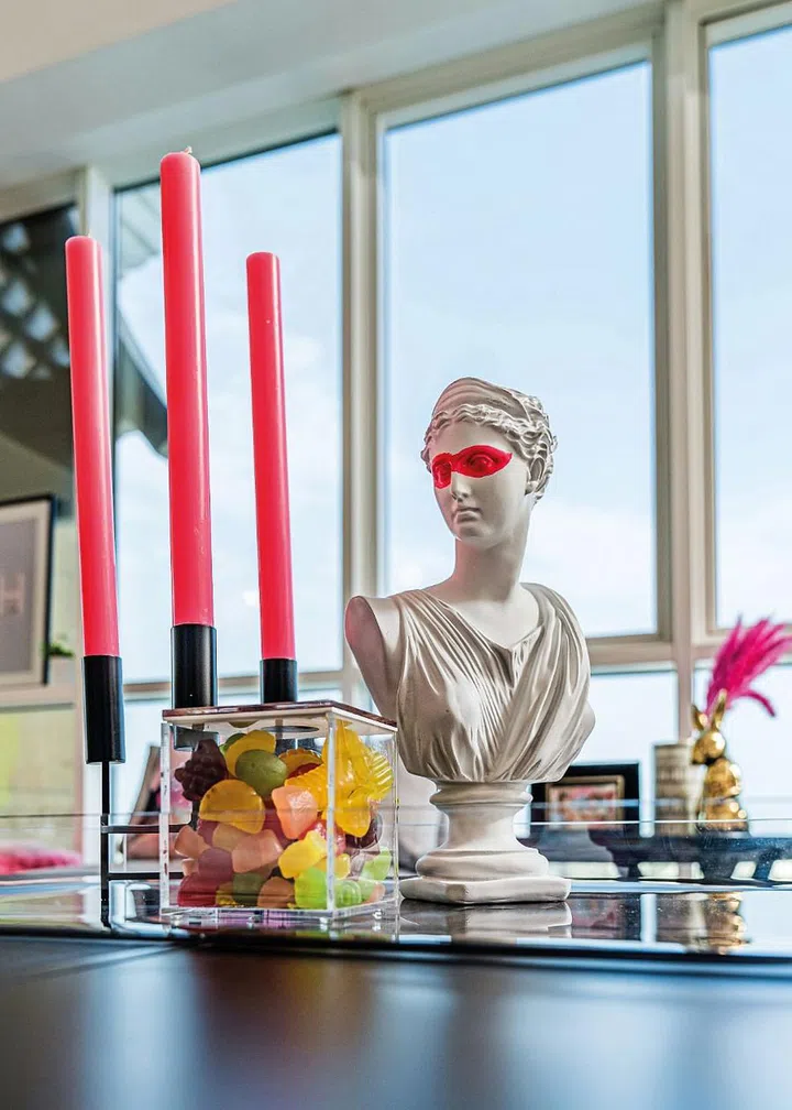 Pink candles are coupled with a statement sculpture in the living space.