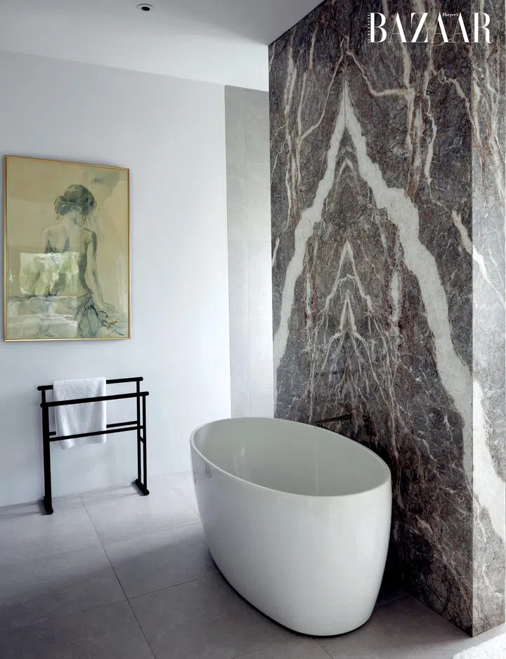 The master bathroom has a stunning book matched marble feature wall. 
Photo: Gan