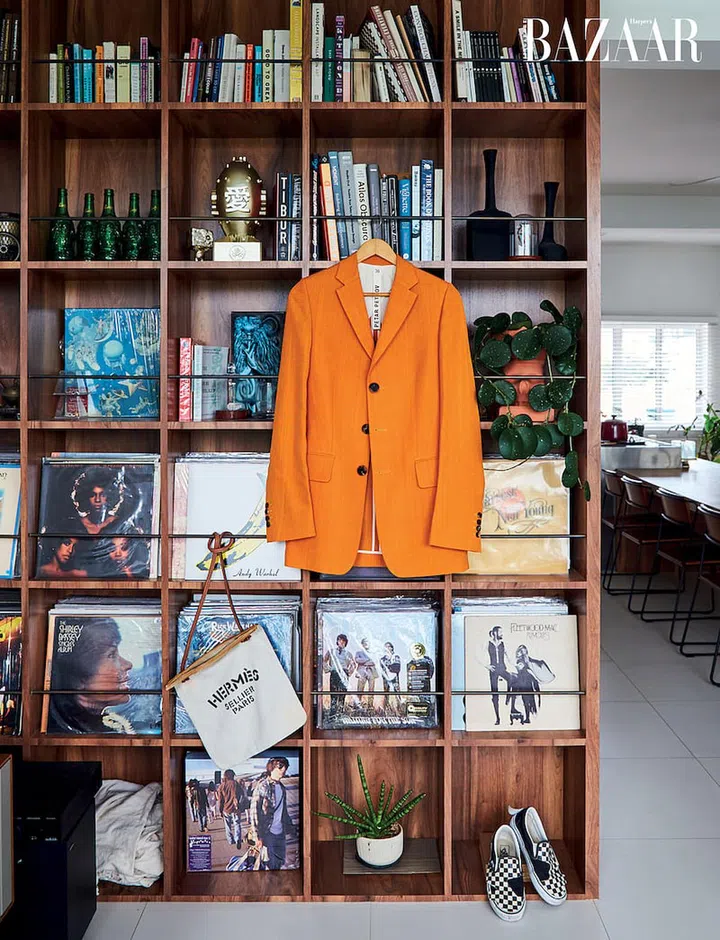 Hanging on the dual-function partition between the dining and living spaces is a Petar Petrov blazer via Net-a-Porter, Hermès Aline grooming bag, and Vans sneakers.