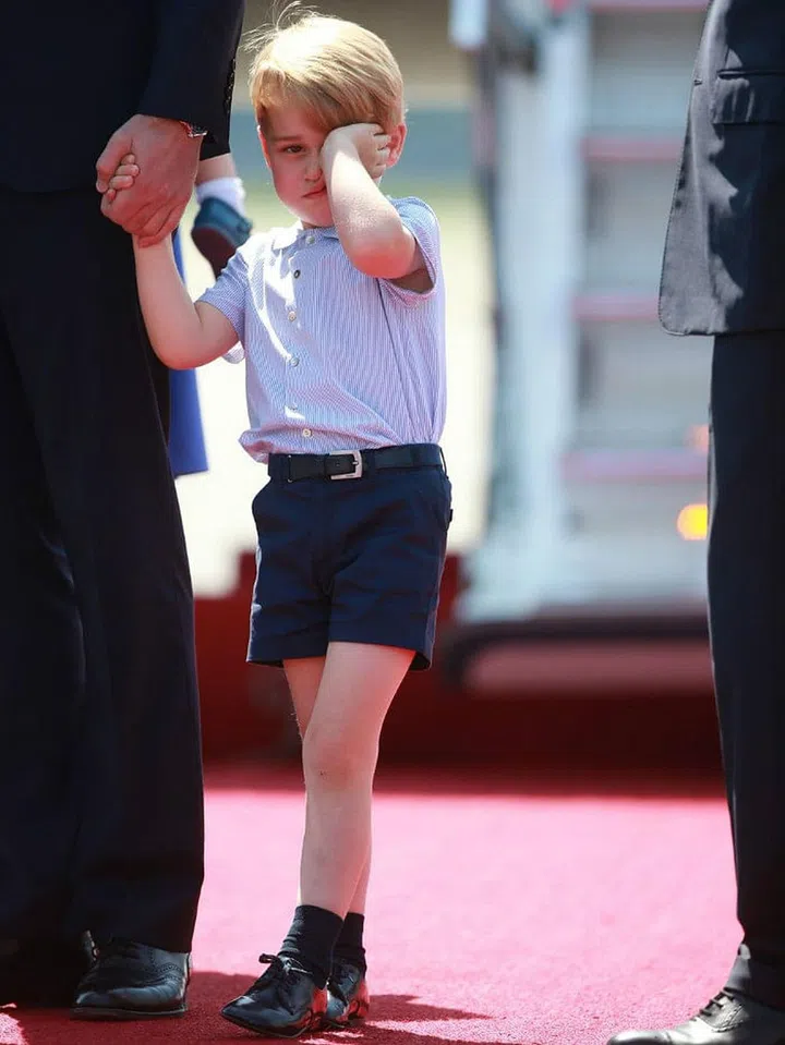 Prince George of Cambridge has a grumpy moment while exiting his plane during a royal trip to Poland and Germany.