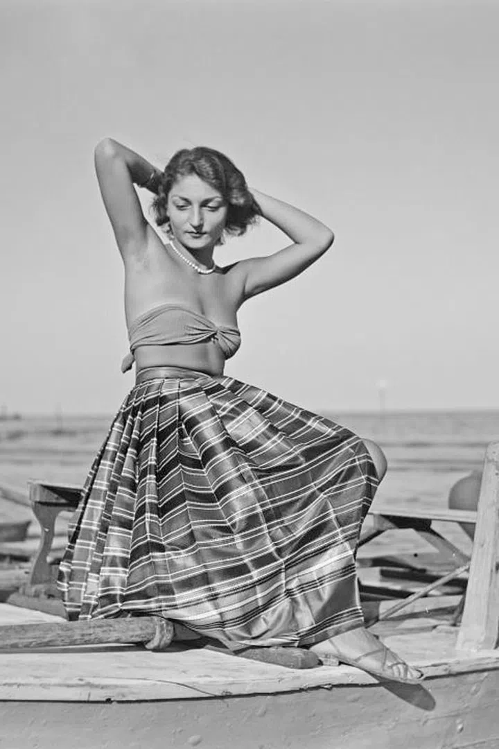 Take the full circle skirt out of the 1950s housewife's kitchen and onto the beach by pairing it with a strapless bikini top and flat sandals.