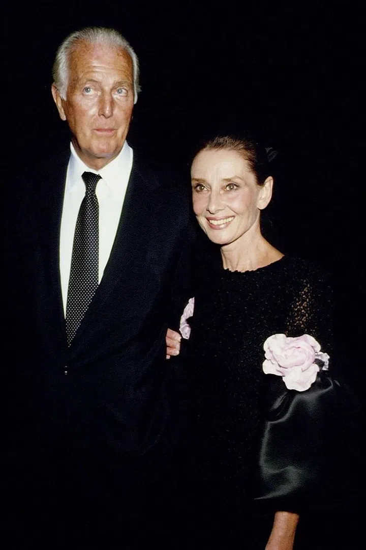 Audrey wears a black satin Givenchy dress adorned with blush pink roses.