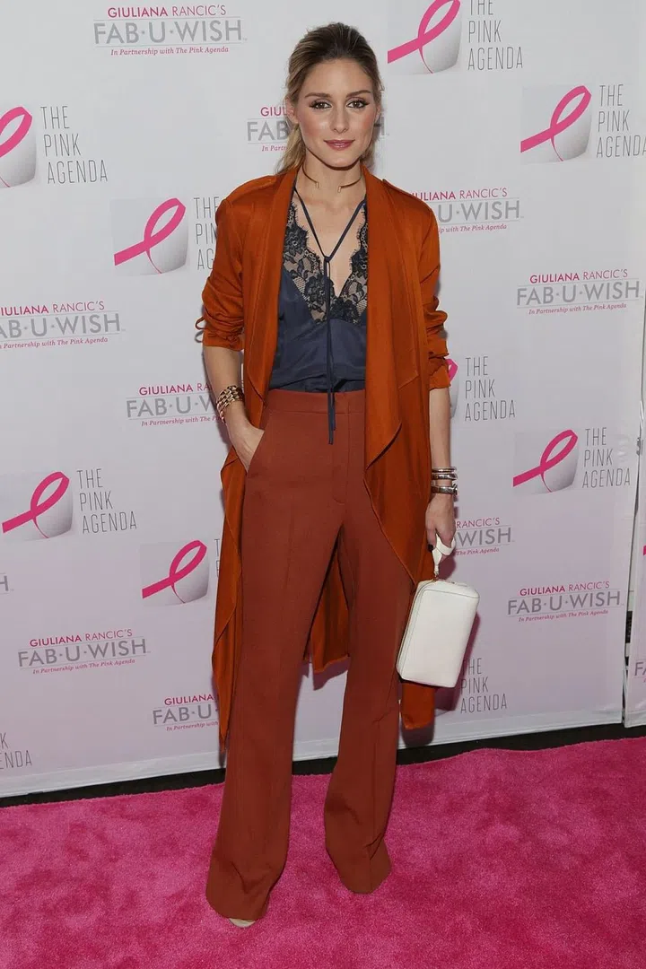 Olivia Palermo styles her rust-coloured trousers with a silk camisole top - an elegant evening look. Photo: Getty 