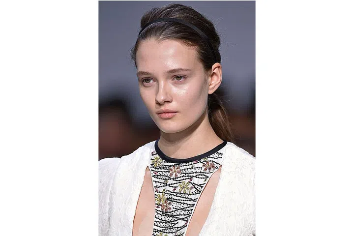 Clean, dewy, hydrated skin was the order of the day at Giambattista Valli. Each model's skin was treated to a quick massage and slathered in serum and moisturiser for a natural glow, before the make-up artist Val Garland applied foundation. The hair was neatly tied back in a low ponytail and accessorised with a hairband ; Photo: Getty