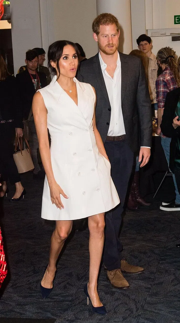 Meghan and Harry attend an event celebrating the thriving arts scene in Wellington, New Zealand. Meghan is wearing a white tuxedo dress by New Zealand-based designer, Maggie Marilyn. Photo: Getty 