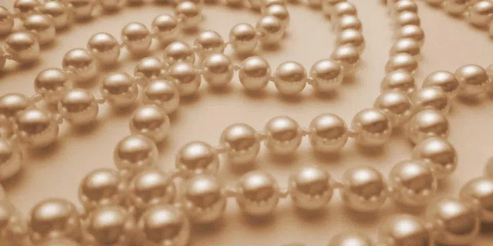 The tooth test is a method of determining if a pearl is genuine or not. Gently slide it across the front of your teeth; the real thing will feel slightly gritty, not smooth.
