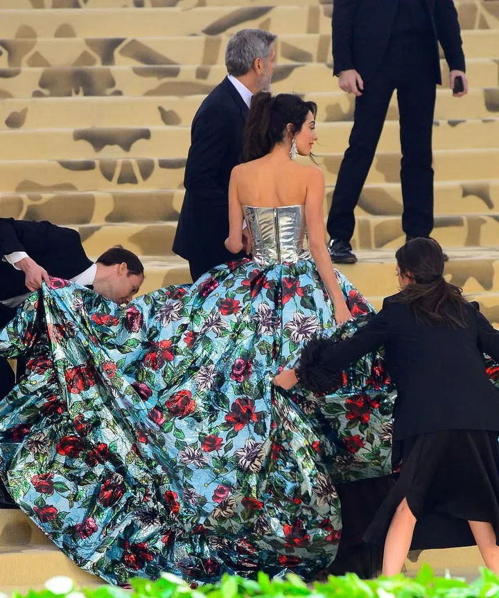 Despite being in pants, the floral parachute behind Amal made it a hassle to get up the steps. Photo: Getty 