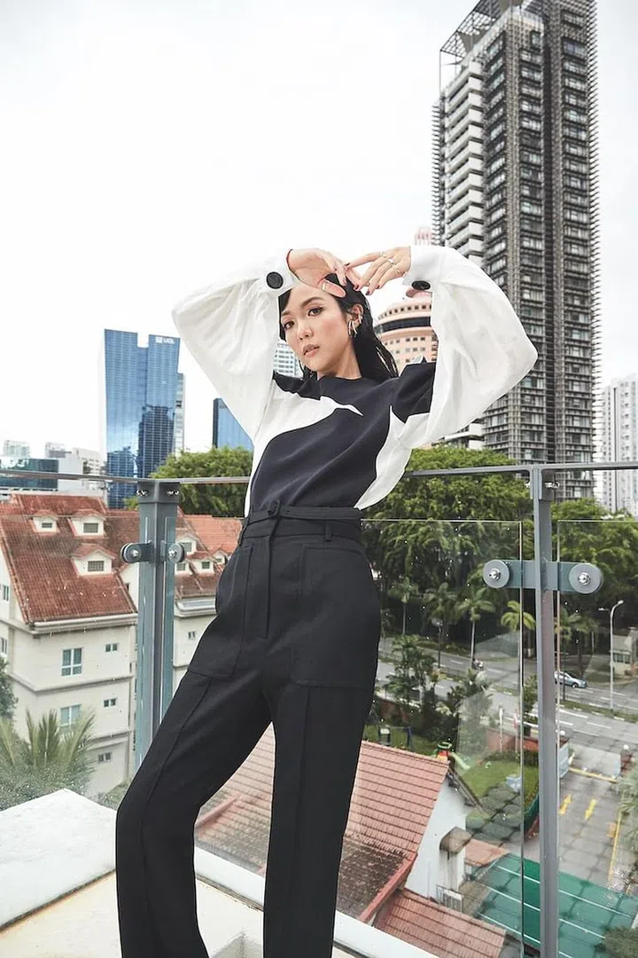 Cao, in a crepe de chine top and wool trousers from Givenchy accessorised with her own ear cuffs and rings, on her balcony. (Photo: Tan Wei Te)