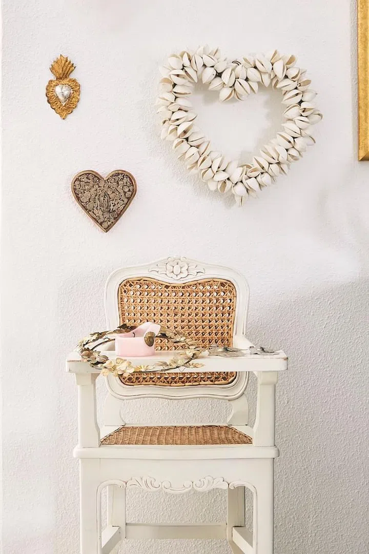 A Mexican milagro and seashell hearts from Bali over a baby chair salvaged from Antoinette and a Santa Maria Novella candle. (Photo: Veronica Tay)