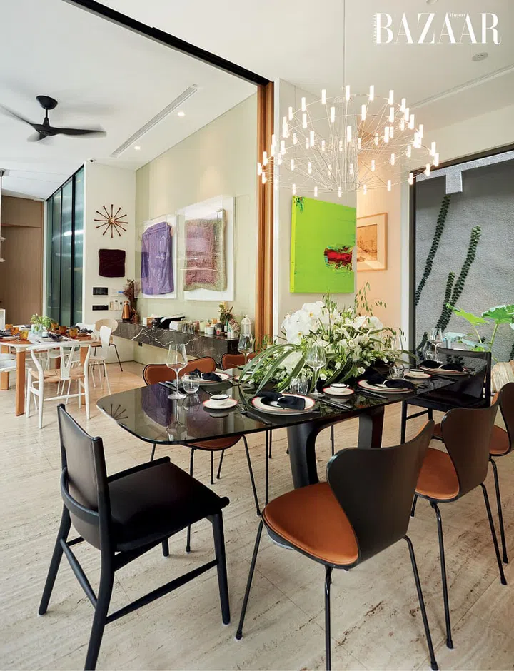 A dramatic Moooi chandelier and leather Arne Jacobsen Series 7 chairs in the dining room. 