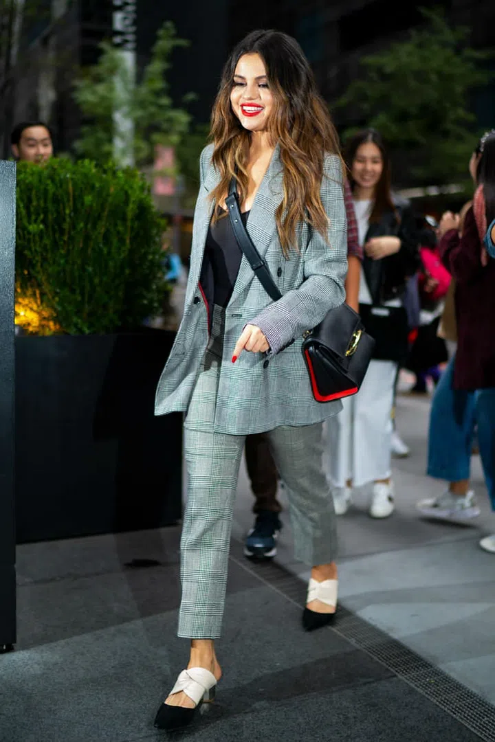 Selena Gomez in a Frame checkered suit with Proenza Schouler two-tone mules and an Alexander McQueen handbag.

Photo: Getty
