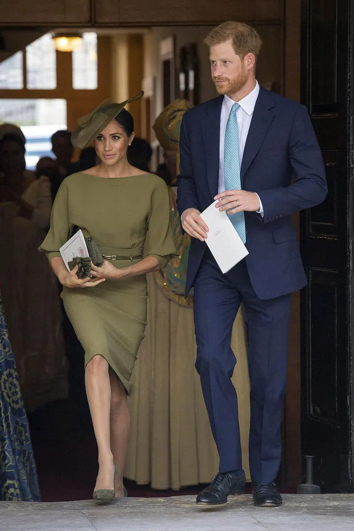 The Duke and Duchess of Sussex exit the chapel following the christening of Prince Louis. For the occasion, Meghan wore an olive green Ralph Lauren dress with a matching hat and suede pumps, while Harry opted for a navy suit. Photo: Getty