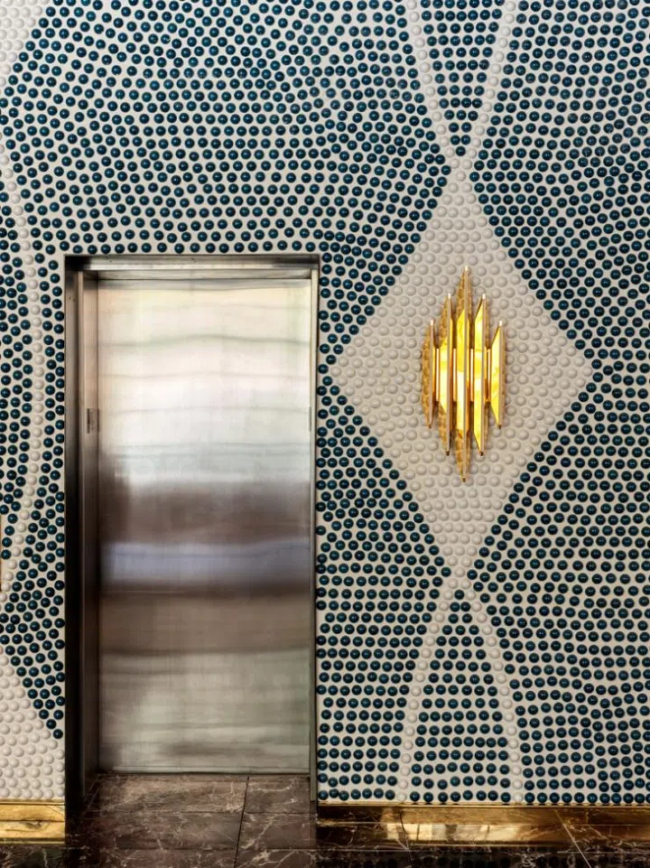 Mosaic style wall and gold sconce at The Manner's public area