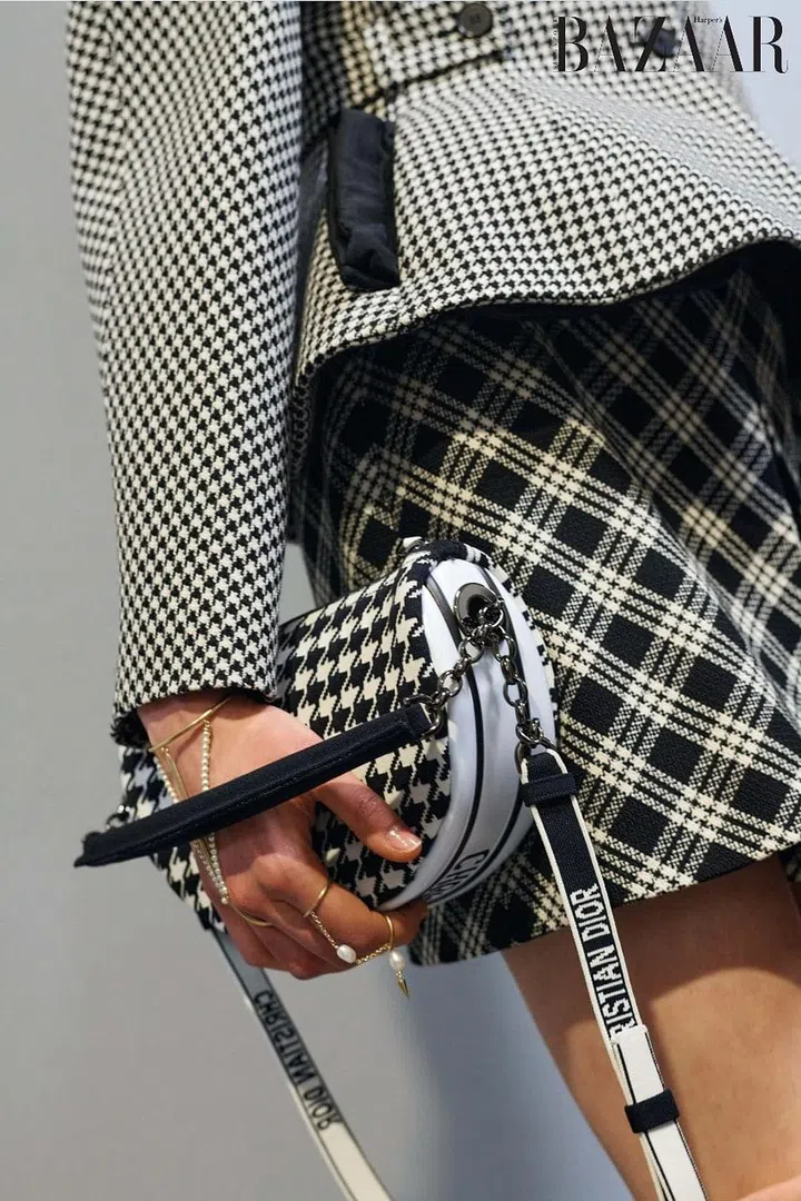Pied de Poule dry virgin wool jacket;
Check‘n’Dior dry virgin wool skirt;
houndstooth technical knit canvas Dior
Vibe bag (small); gold-finished metal and
resin pearl D-Renaissance hand jewel;
gold-finished metal and freshwater
pearl D-Renaissance ring, Dior