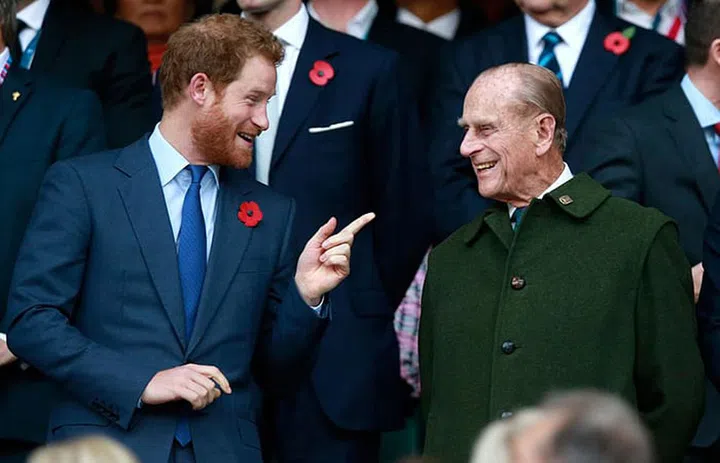Prince Harry and his grandfather Prince Phillip joking around at the 2015 Rugby World Cup final match between New Zealand and Australia in London.