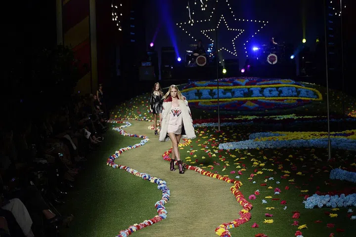 Natural elements mix with a celebration of dramatics in this Tommy Hilfiger set featuring bright green grass, artificial flowers and giant sparkling stars. The blend of natural and artificial makes for a beautifully eye-catching paradox to incorporate into your interior decor plan. 