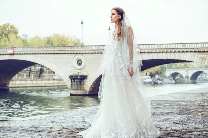 Years working in Monique Lhuillier's bridal atelier gave Sabrina Dahan the street cred to launch her namesake collection last season, inspired by her own engagement. The L.A. based designer spent summers in Paris growing up, contributing to her effortlessly elegant aesthetic focused on light-as-air volume and intricate handwork. This designer released a capsule of five delicately embroidered pieces to start for Fall 2016, emphasizing quality over quantity, and continued that knack for fine-tuned editing when she launched a less-than-ten dress collection for Spring 2017.