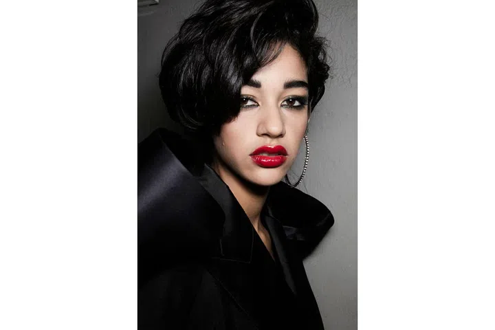 The vibe at Jean Paul Gaultier was distinctly Eighties. Every model had a full look with a striking red lip, bold blusher, full brows, kohl-lined eyes and lashings of mascara, while the hair styles ranged from punky mullets to voluminous afros ; Photo: Getty