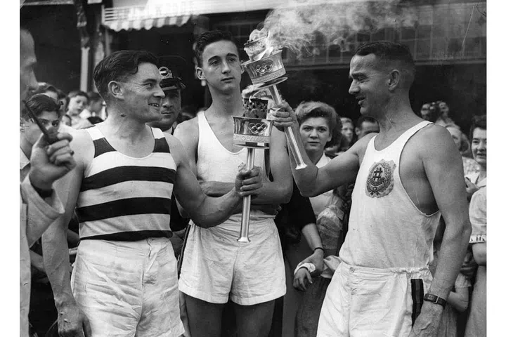 1948
Athletes pass the torch at the Opening Ceremony in London. After WWII, stretch fabrics in sportswear become more common, since they're less restricting on the form during exercise. Photo: Getty