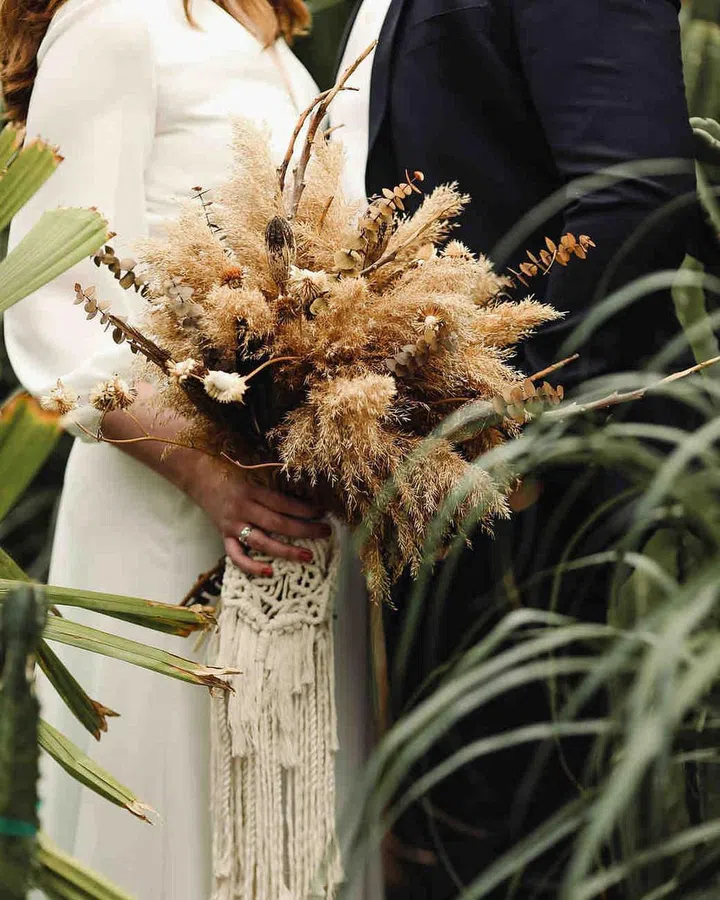 We get it, boho was big–but now, scale it back to small details. A knotted lace used in unconventional ways offers an elegant dose of bohemian style to any modern look. Textural elements and fringe make for a spirited bouquet, especially when paired with a minimal bridal gown and tawny-toned florals. Just be cautious to use this crafty folklore facet sparingly—with something this crafty in feel, a little bit goes a long way.

Photo: Getty
