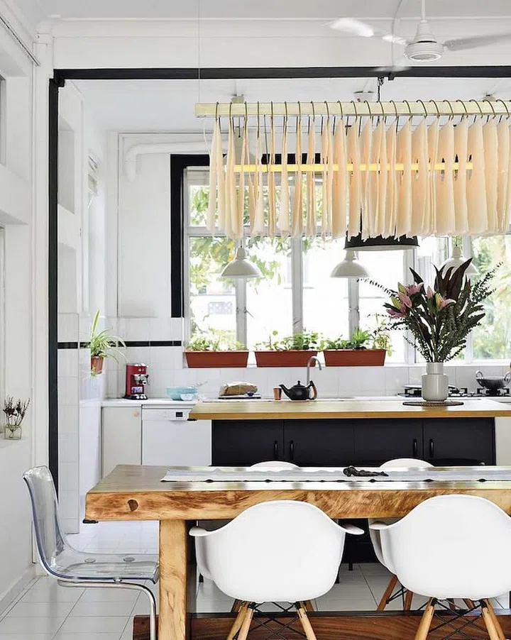 A suar wood dining table from Indonesia and a rice paper lamp from Anjali’s favourite designer in Goa lend warmth to the dining area. (Photo: Carli Teteris, courtesy of Grounded)


