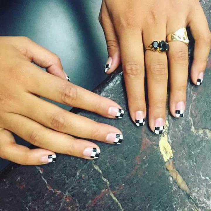 For this checkerboard nail, start with a classic french tip. Once dry, apply black boxes to create the design and finish with a clear topcoat. 
Design by @mpnails