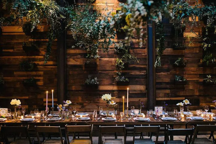 Sophisticated wood walls and cozy wooden banquet tables in opulent chestnut and maples are understated and elegant in all the right ways. Scratch the table cloth and let your table and chairs live naturally in the space for a monochromatic look that feels more modern than it does rustic. Leverage lush greenery and fall foliage for the ultimate backdrop to your intimate autumn affair.

Photo: Getty