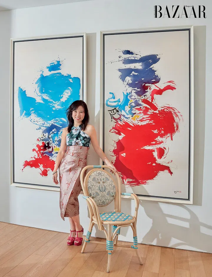 A supporter of the local arts and fashion communities, Dr Sue Anne Toh stands in front of a pair of paintings by Singaporean artist Tan Teo Kwang and a rattan chair from Ong Shunmugam, wearing her own Ong Shunmugam dress, accessorised with, vintage earrings, Hermès bracelet, Tiffany & Co. ring and vintage sandals by Yves Saint Laurent.