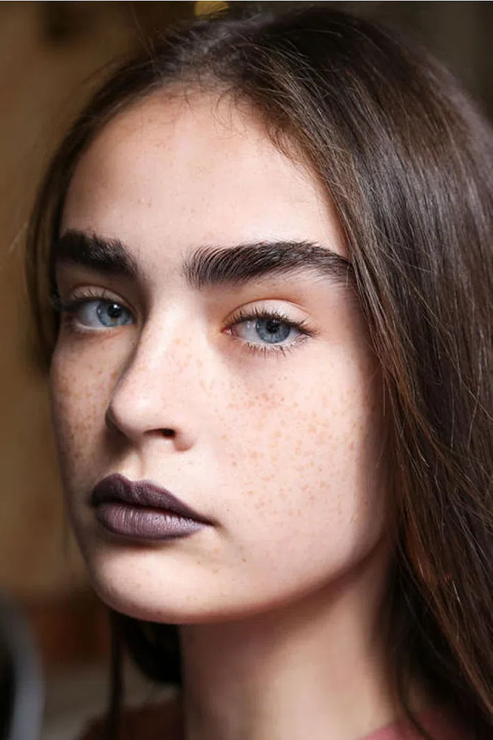 The lipstick at Acne Studio's spring 2017 show was gray, purple, and metallic. Makeup artist Aaron de May used MAC Cosmetics Deep Rooted Lipstick to start, then layered on different eyeshadows to get the metallic effect.