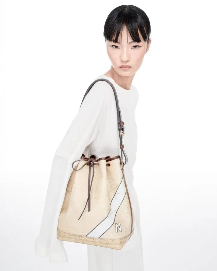 Model in Louis Vuitton top and skirt carrying the Time Trunk Noe bag.