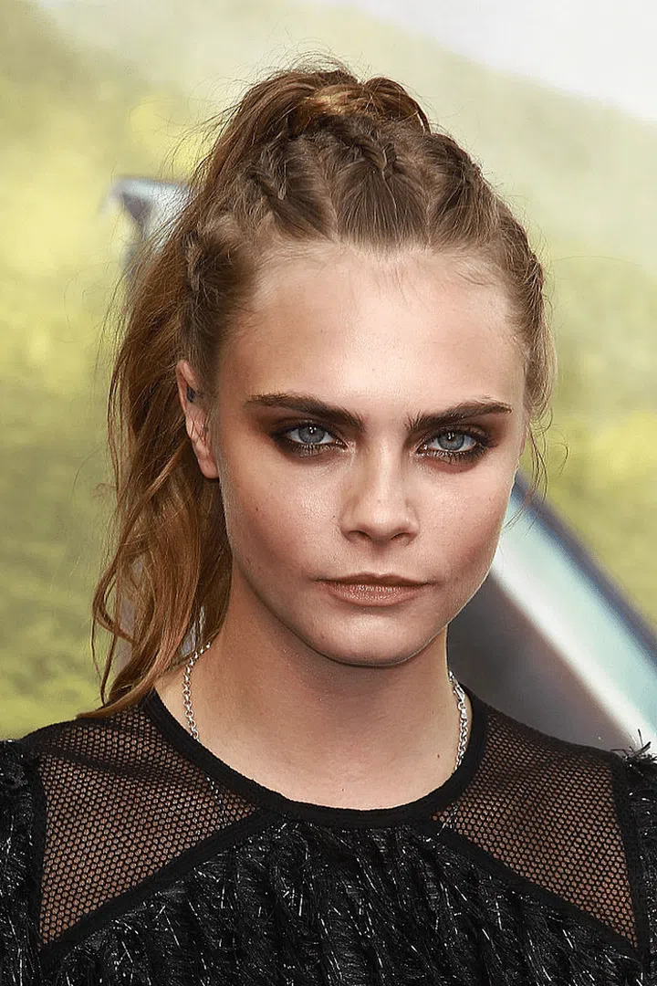 A high, braided ponytail with dewy skin and dark, stained lips to keep her looking young while screaming edge.