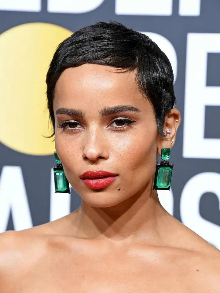Everything from her pixie cut, full brows, perfectly sculpted cheeks to orange-red lips are all perfection.