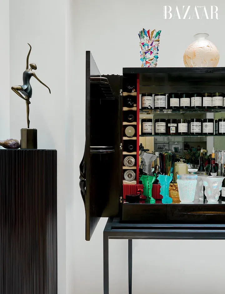 An armoire houses her collection of wines and candles.