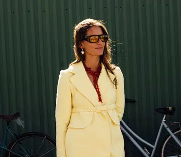 best valentine’s day jewellery gifts | woman in yellow blazer wearing heart shaped jewellery during fashion week