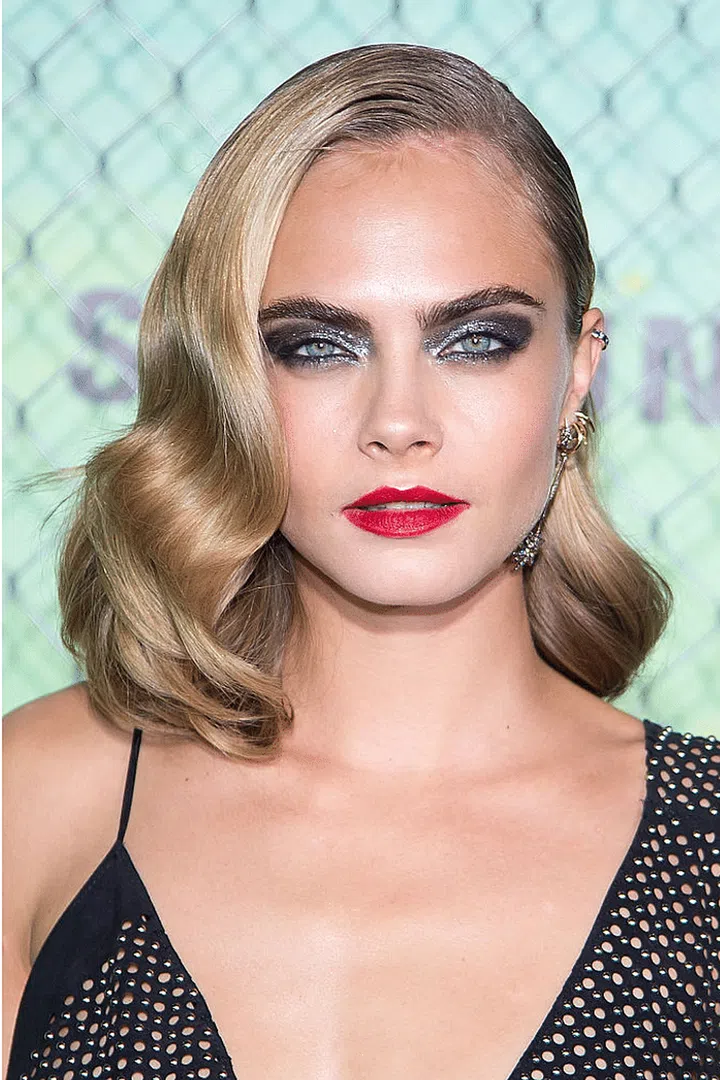 Cara doesn't shy from the shock factor in smokey silver lids and a neon red lip.