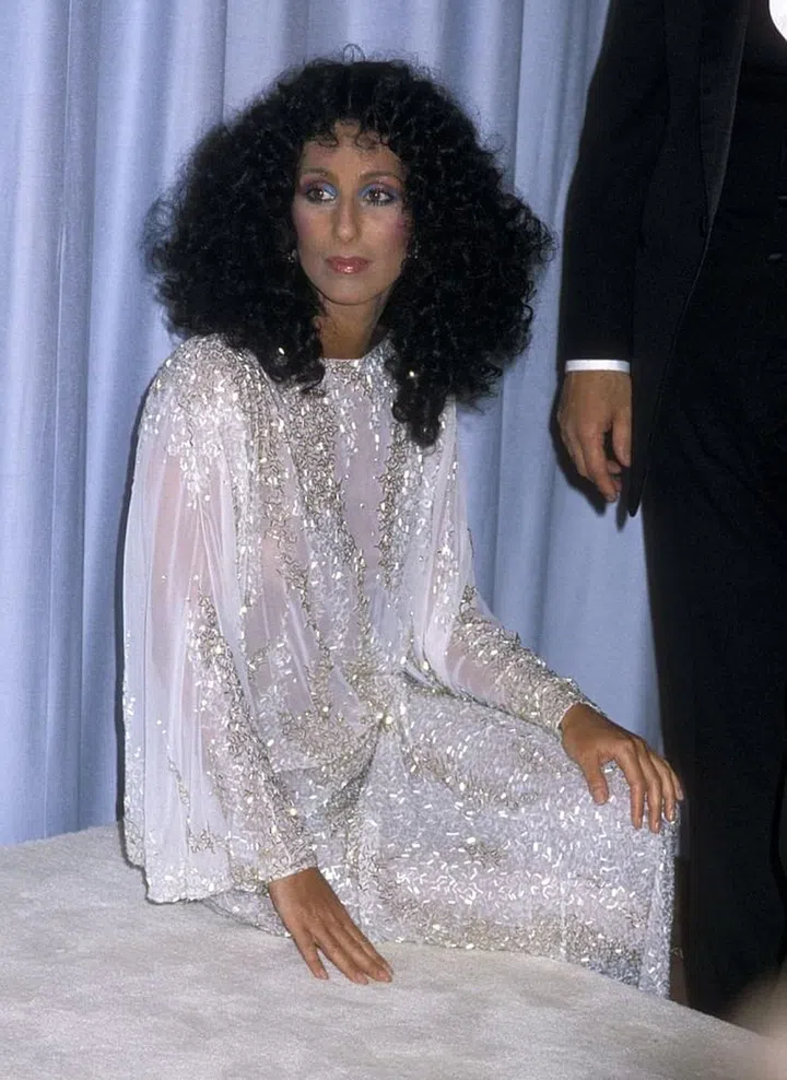 New decade, new Bob Mackie style. For her first Oscars appearance of the '80s, Cher traded in her belly-baring looks of the past for a long-sleeve, full-length gow. Don't worry though, it was still see-through. 