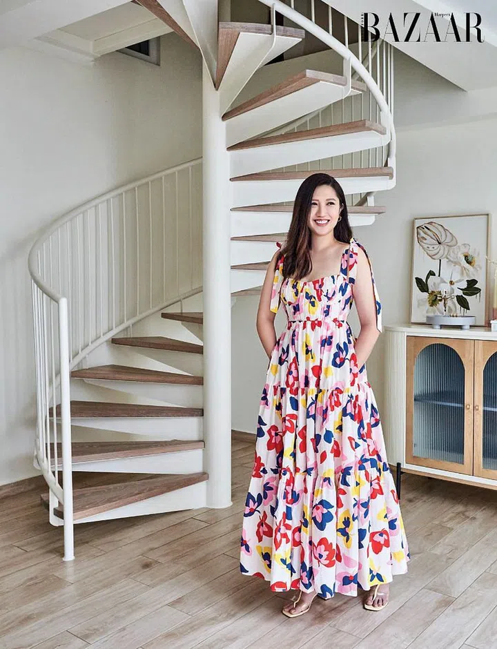 Hanni Wong, in a Kate Spade New York dress, Tory Burch heeled sandals and her own Swarovski earring, in front of the spiral staircase—one of her favourite additions to the house.