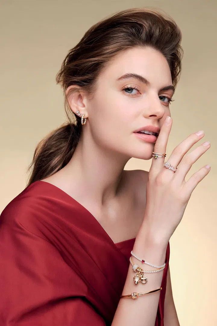 Rose gold-plated and crystal Sparkling Pear Stud earrings; gold-plated and crystal Timeless Sparkling Row Eternity Hoop earrings; Sparkling Band ring; Sterling silver Moments Honey Eternity Circle ring; rose gold-plated and crystal Timeless sparkling Pear Halo ring; Alternating Sparkling Band ring; Sterling silver and crystal Red Sparkling Heart Tennis bracelet; gold plated and crystal Timeless tennis bracelet with Moments Sparkling Pavé Triple-row charm, Heart Snowflake Snow Globe Dangle charm and Rocking Unicorn Dangle charm; rose gold-plated and crystal Moments bracelet, Pandora. Top, H&M