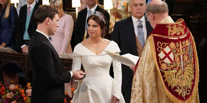 The bride and groom hold hands at the alter.