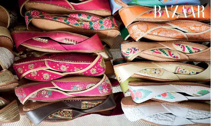  A drawer containing three layers of handcrafted khussas (traditional embroidered Pakistani shoes) arranged by their colours.